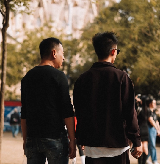 Dos hombres de espaldas caminando en un parque al aire libre