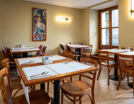 Restaurante acogedor con mesas de madera y decoraci&oacute;n art&iacute;stica.