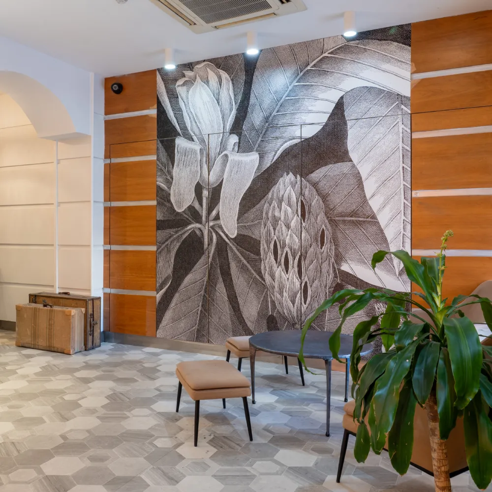 Mural en blanco y negro de hojas y flores en un sal&oacute;n moderno.