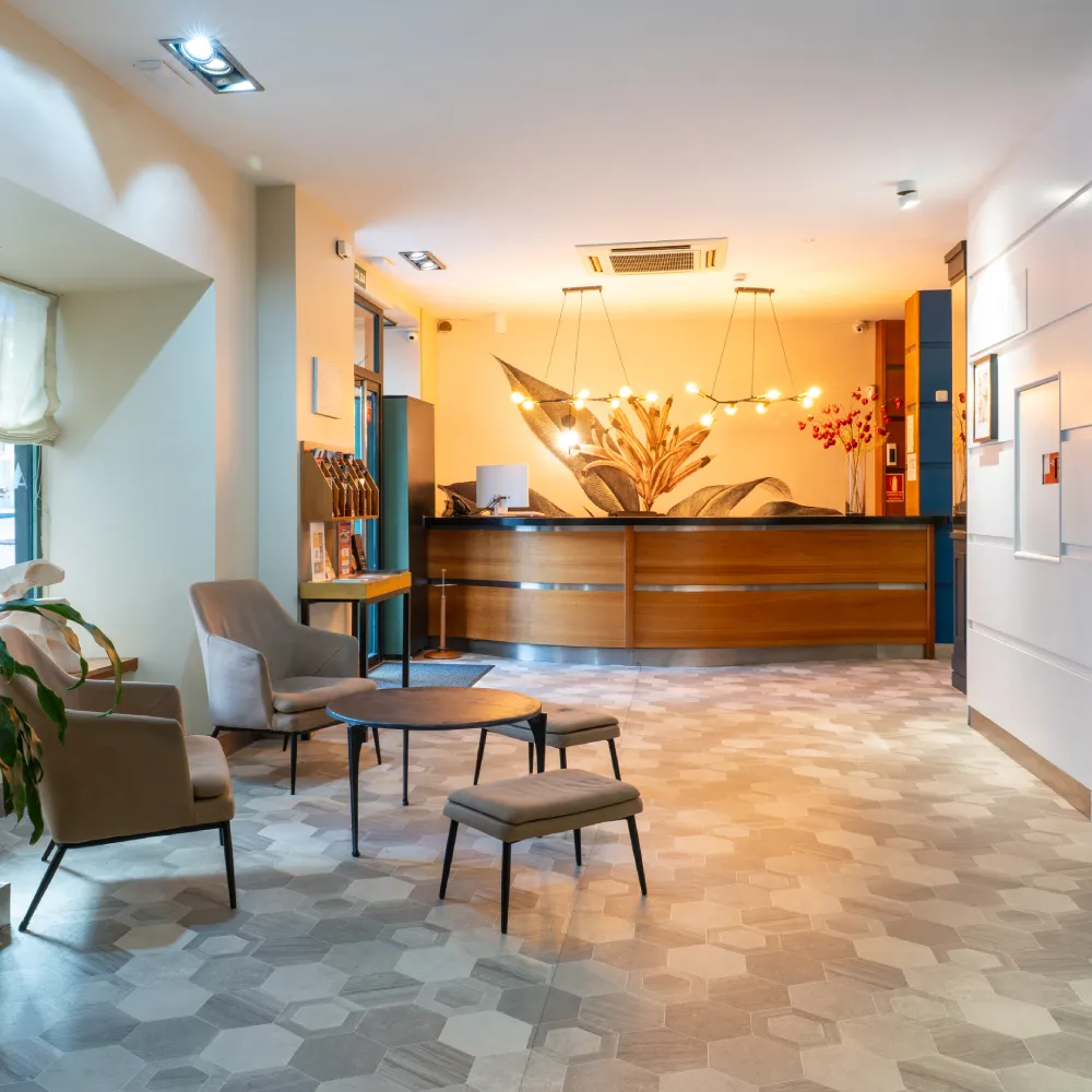 Recepci&oacute;n de hotel moderna con sillas y mesa en sal&oacute;n decorado.