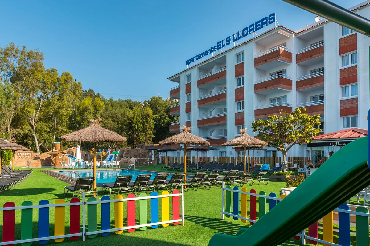 Hotel con piscina y jardines, sombrillas y tumbonas al aire libre