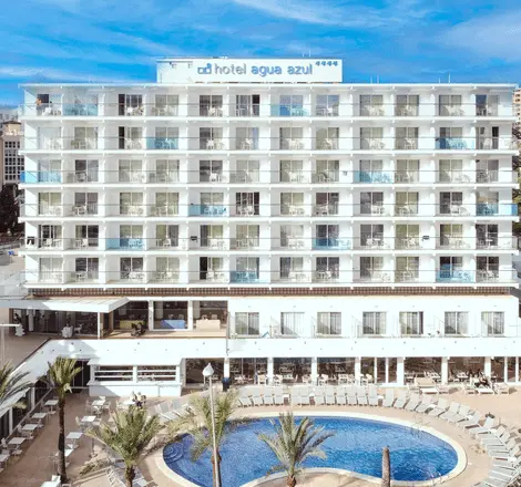Hotel con piscina y palmeras, fachada blanca frente al mar