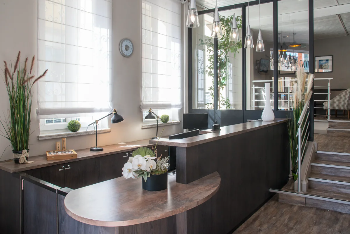 Mostrador moderno con decoraci&oacute;n de plantas y l&aacute;mparas colgantes.