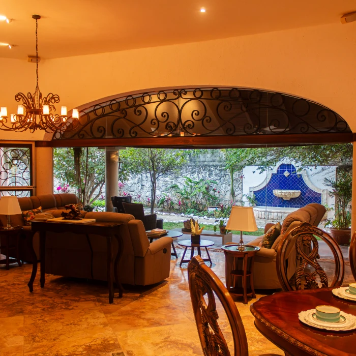 Sala elegante con vista al jard&iacute;n y fuente decorativa.