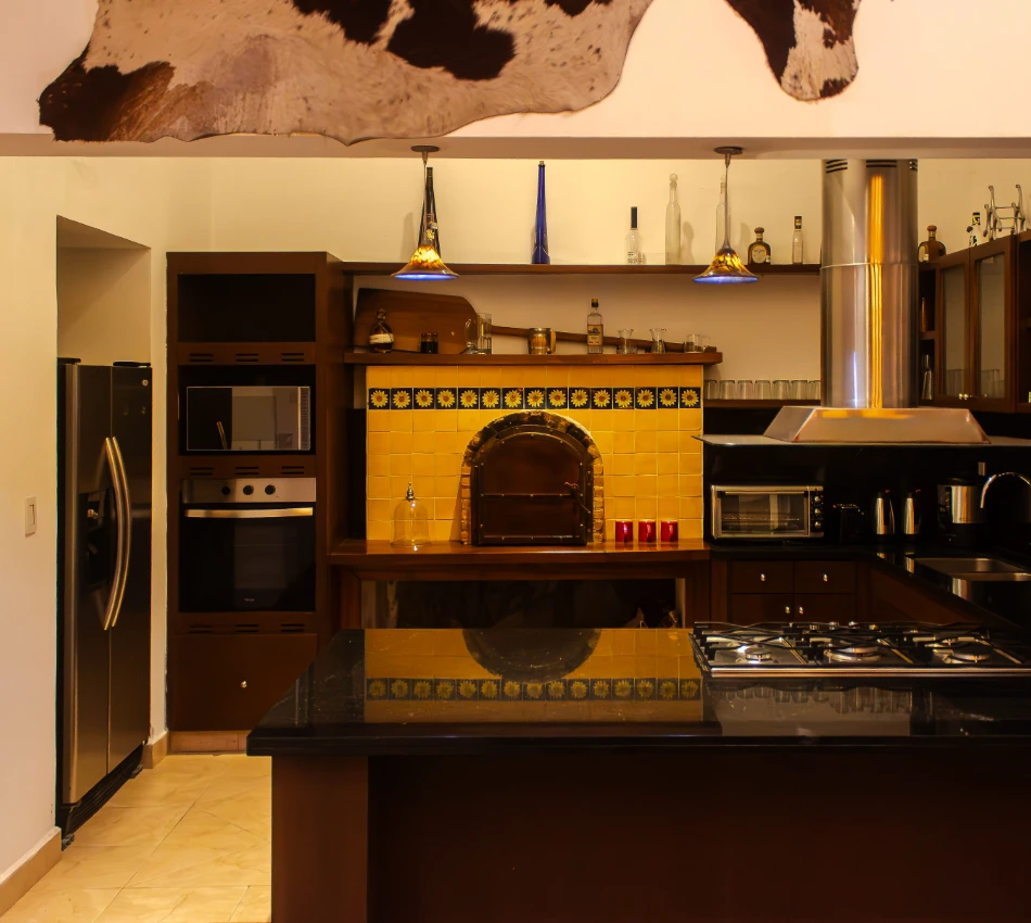 Cocina con horno de piedra, estufa y decoraci&oacute;n r&uacute;stica en tonos c&aacute;lidos.