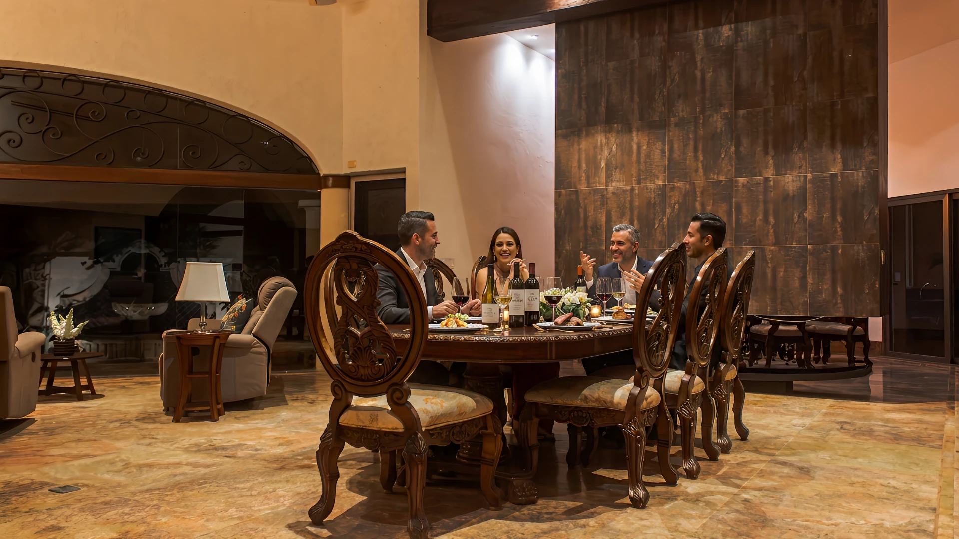 Personas cenan en una elegante mesa de comedor en un ambiente c&aacute;lido y acogedor.