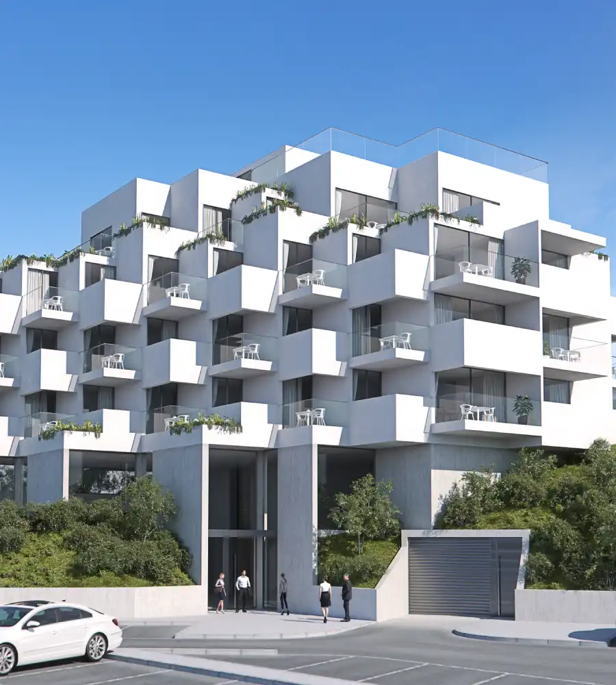 Edificio blanco moderno con balcones y vegetaci&oacute;n bajo un cielo azul.
