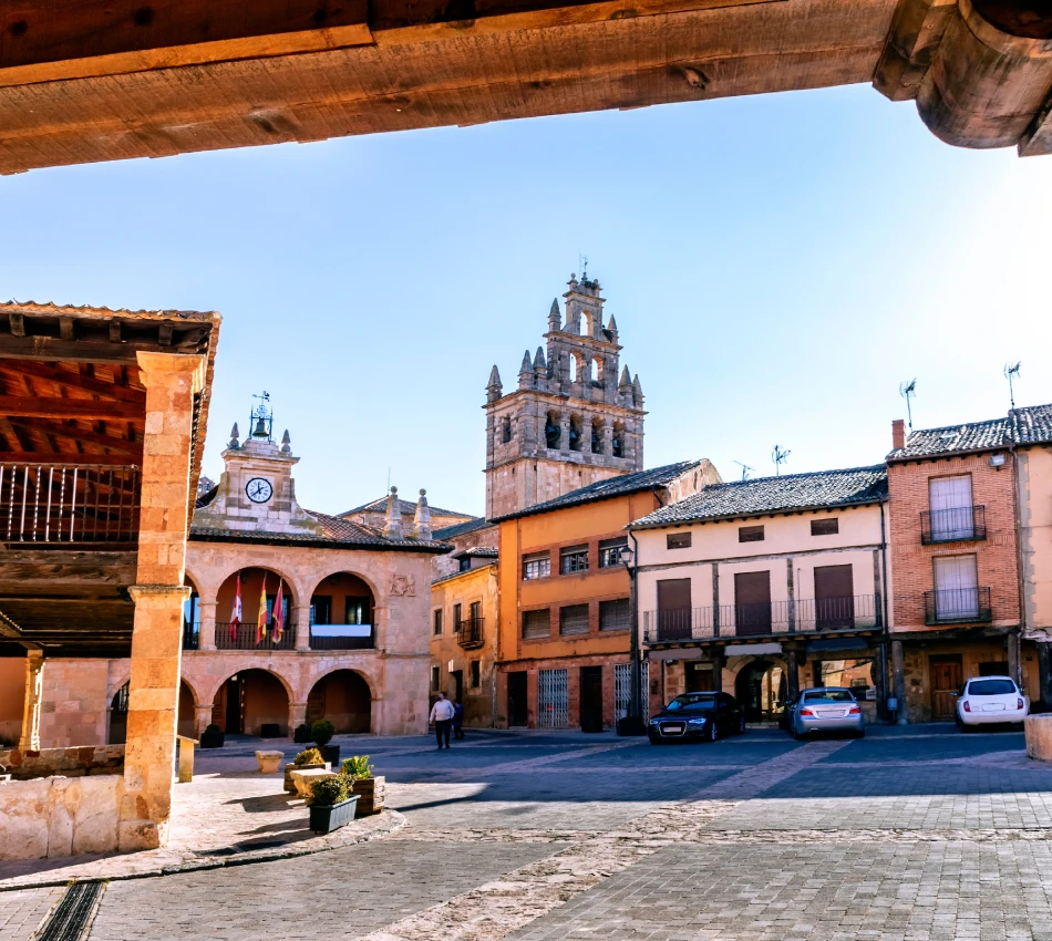 Plaza con edificios hist&oacute;ricos y torre en un d&iacute;a soleado.