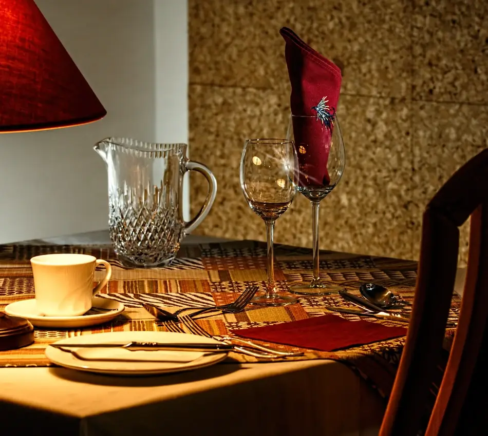 Mesa elegantemente servida con copas y servilleta roja.