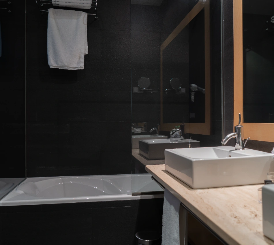 Ba&ntilde;o moderno con lavabo rectangular y espejo grande.