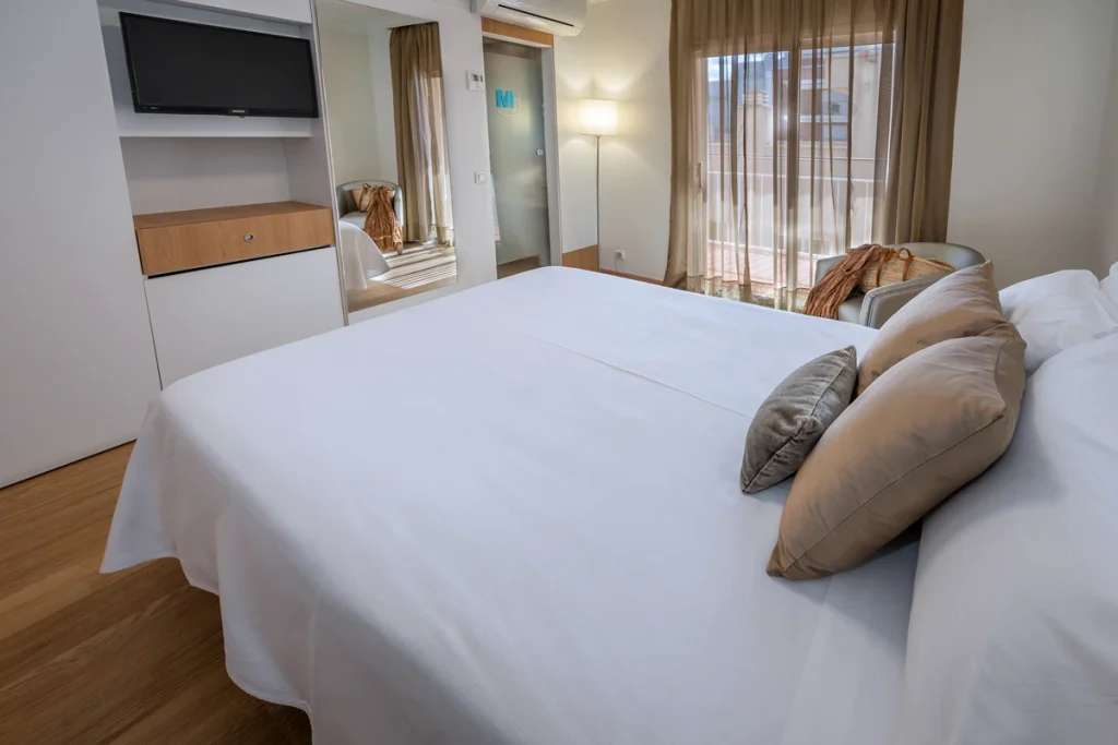Habitaci&oacute;n de hotel con cama, escritorio y ventana.