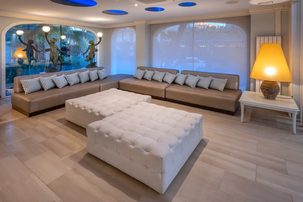 Sala de estar moderna con sof&aacute;s grises y pufs blancos.
