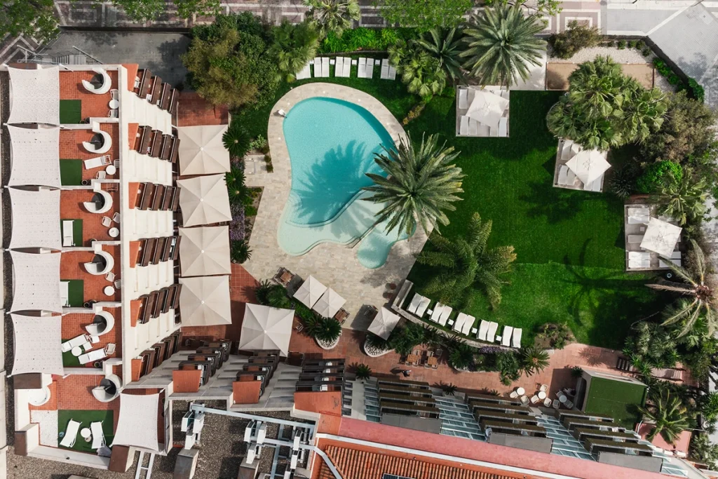 Vista a&eacute;rea de un complejo de edificios con piscina cerca del mar.