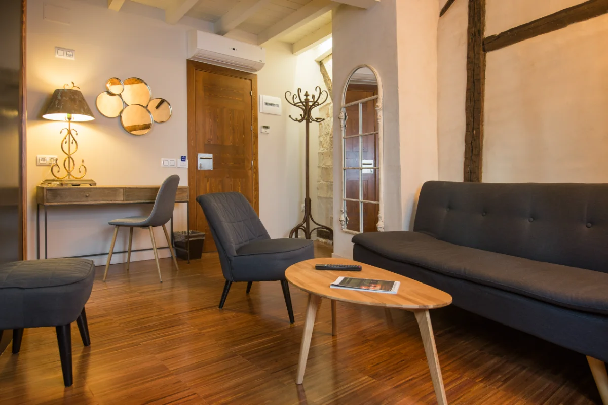 Sala acogedora con sofá gris, mesa de centro y escritorio con silla.