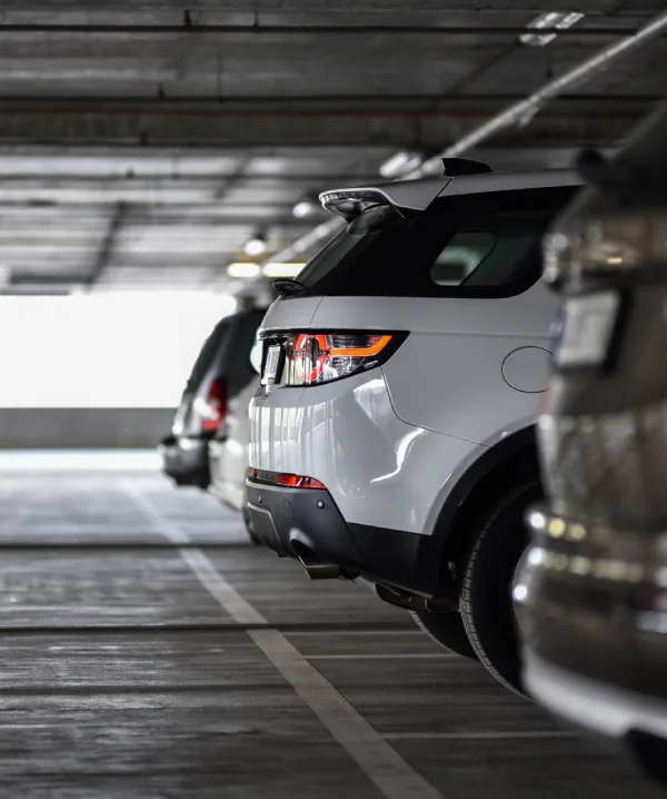 Vista de un coche blanco en un estacionamiento subterr&aacute;neo, de espaldas