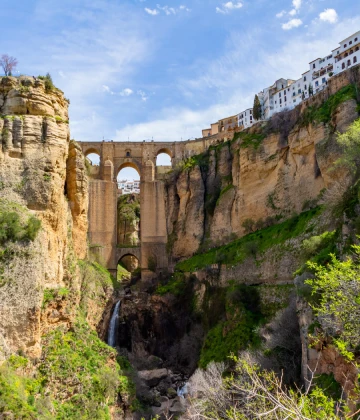 Acueducto y casas blancas sobre un ca&ntilde;&oacute;n en paisaje mediterr&aacute;neo.