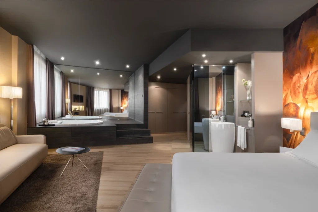 A modern luxury hotel room featuring a spacious layout with elegant furnishings.