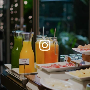 Jarras de jugo y snacks en mesa de desayuno con decoraci&oacute;n verde