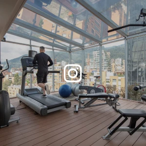 Hombre entrenando en gimnasio con vista a rascacielos desde el vidrio