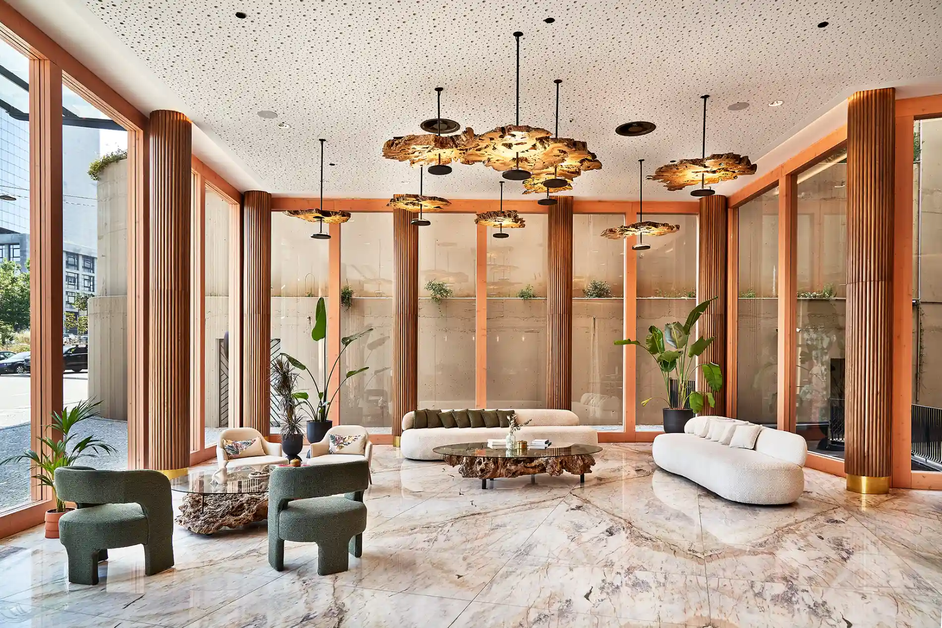 Sala moderna com sof&aacute;s, cadeiras, mesas e plantas, com ilumina&ccedil;&atilde;o elegante.