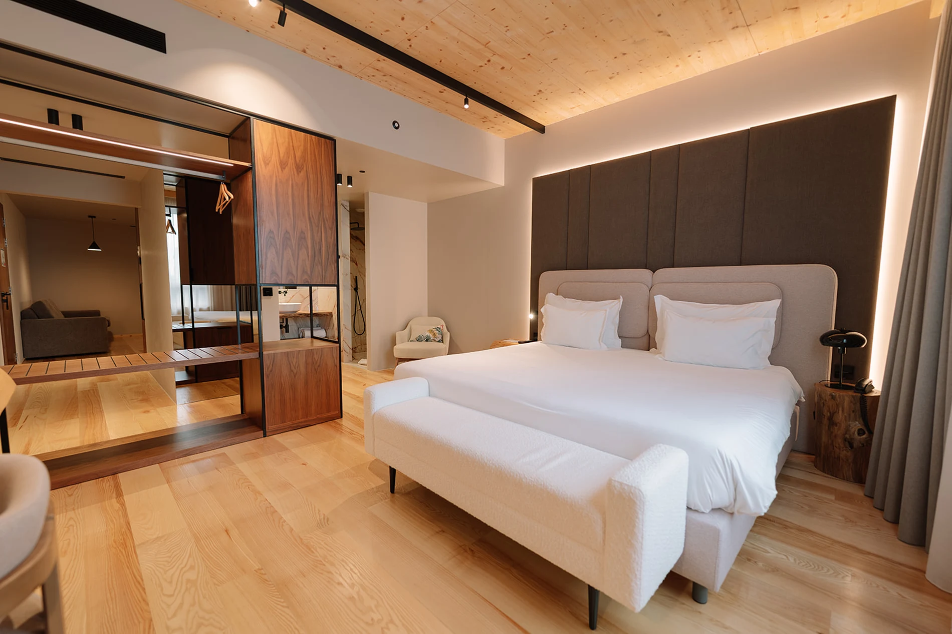 Quarto moderno com cama de casal, arm&aacute;rio e poltrona.