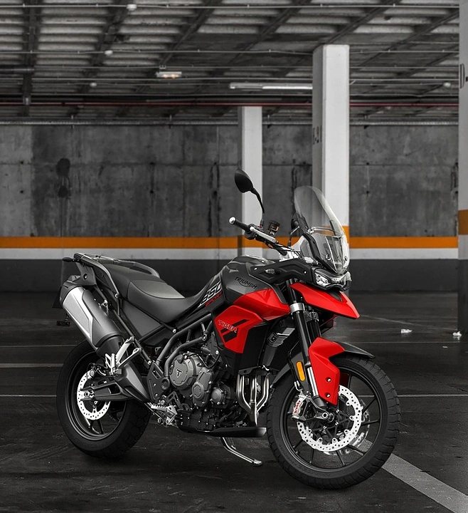 Moto esportiva vermelha e preta estacionada em garagem com colunas.