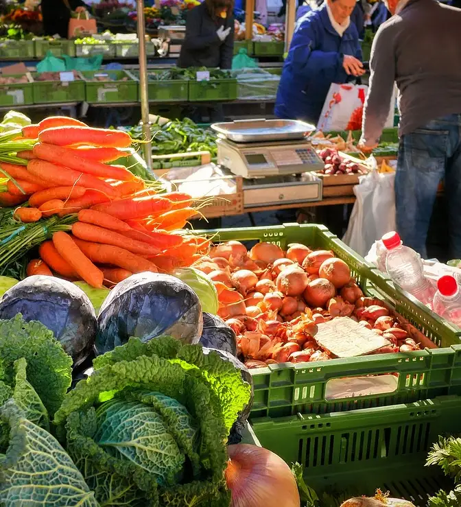 Banca de feira com vegetais frescos e balan&ccedil;a.