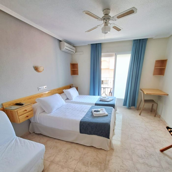Habitaci&oacute;n con dos camas individuales, aire acondicionado y decoraci&oacute;n sencilla.