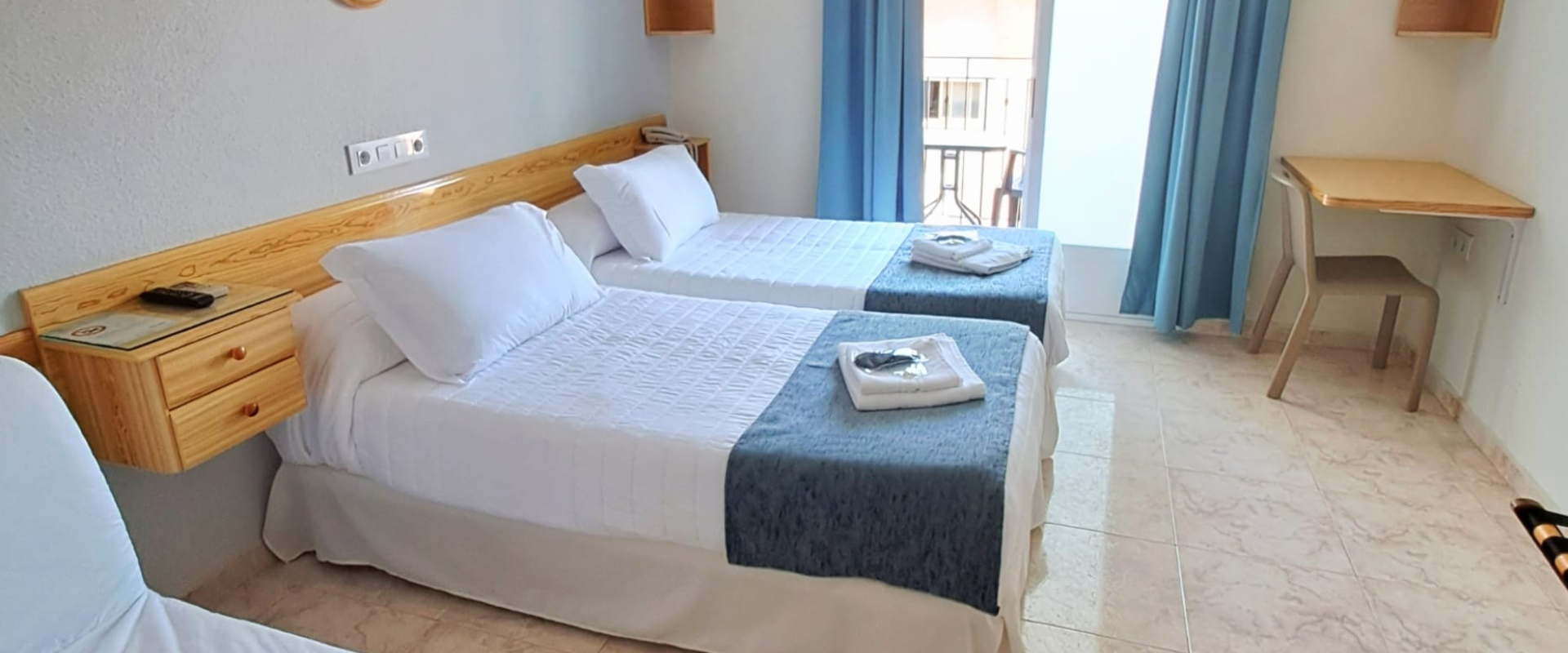 Habitaci&oacute;n con dos camas individuales, aire acondicionado y decoraci&oacute;n sencilla.