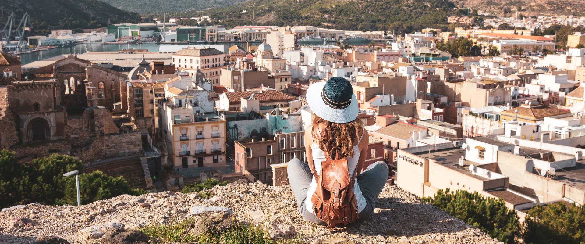 Persona con sombrero observa la ciudad desde un mirador alto.
