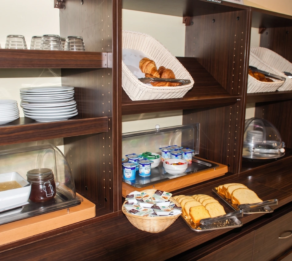 Buffet de petit-d&eacute;jeuner avec pain, croissants et yaourts.