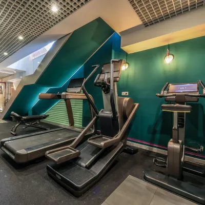 Gimnasio con varias m&aacute;quinas de ejercicio y bicicleta est&aacute;tica.