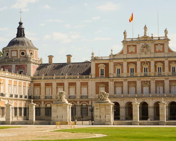 Fachada hist&oacute;rica con c&uacute;pula y bandera en un edificio de plaza.