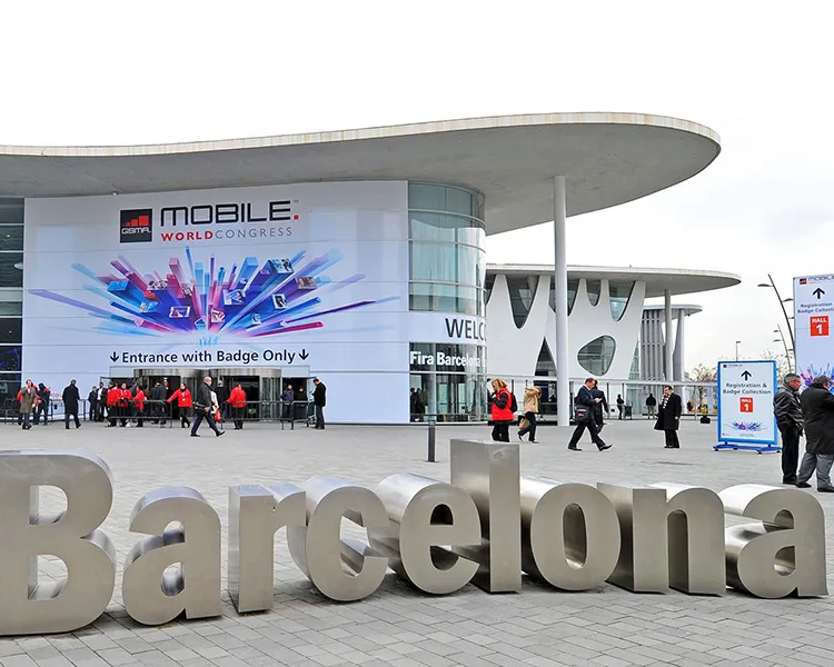 Entrada al Mobile World Congress con letrero &ldquo;Barcelona&rdquo; y personas.