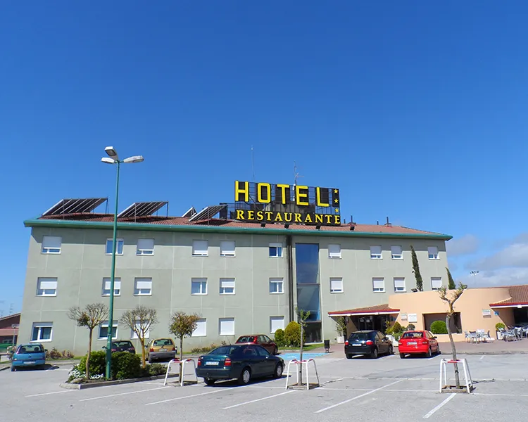 Fachada de hotel con letrero &ldquo;HOTEL RESTAURANTE&rdquo; bajo cielo azul