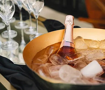 Copas con champ&aacute;n en cubeta con hielo durante un brindis.