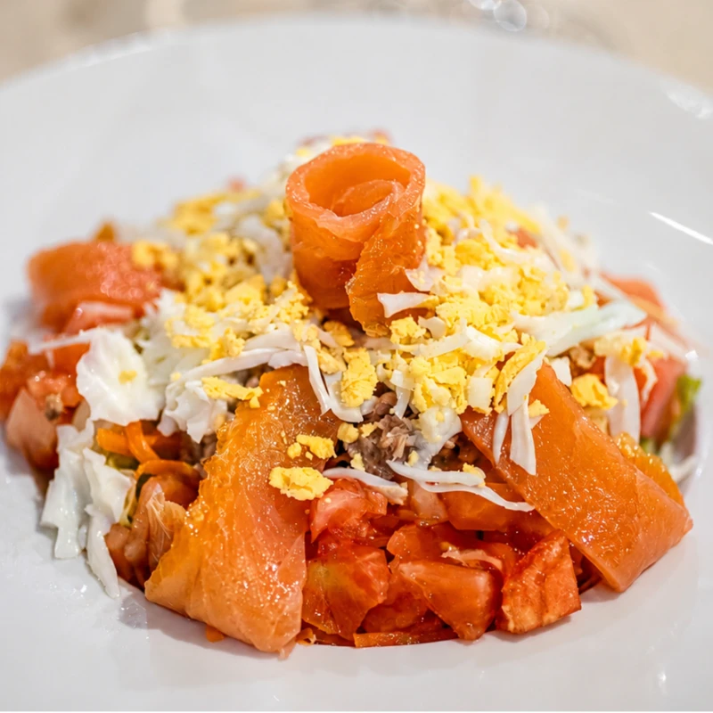 Ensalada con salm&oacute;n, tomate, huevo rallado y virutas de pan crujiente