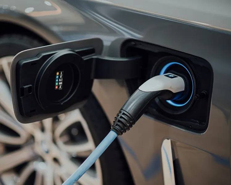 Carga de un coche el&eacute;ctrico con enchufe conectado en el puerto.