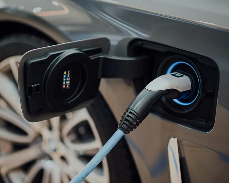 Cable de carga enchufado a un veh&iacute;culo el&eacute;ctrico, conector en el puerto