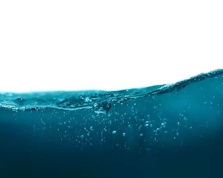 Primer plano de una ola azul con burbujas bajo el agua