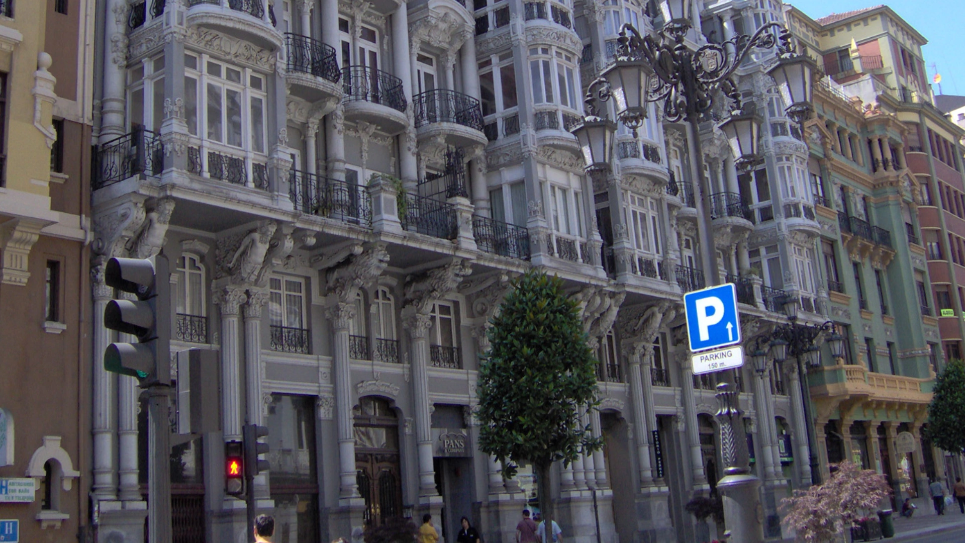 Fachada de edificio cl&aacute;sico con se&ntilde;al de parking y buz&oacute;n en la calle