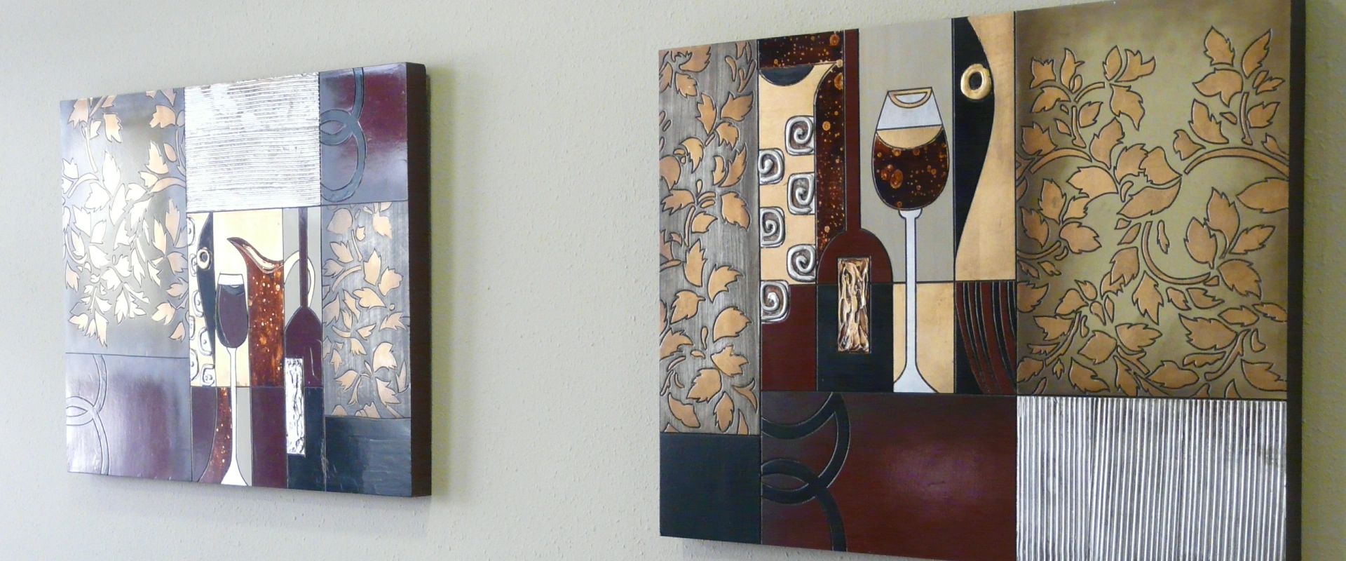 Cuadros decorativos con copas de vino y hojas oto&ntilde;ales en una pared blanca.