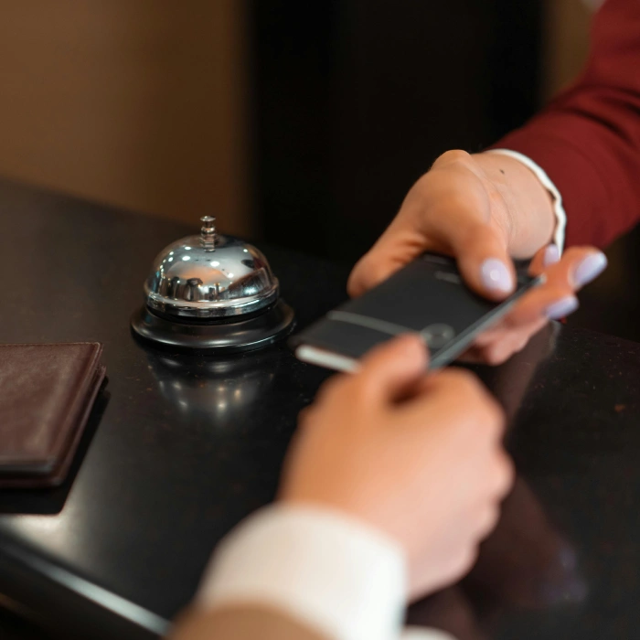 Recepcionista toma una orden con conserjer&iacute;a y timbre de mostrador.