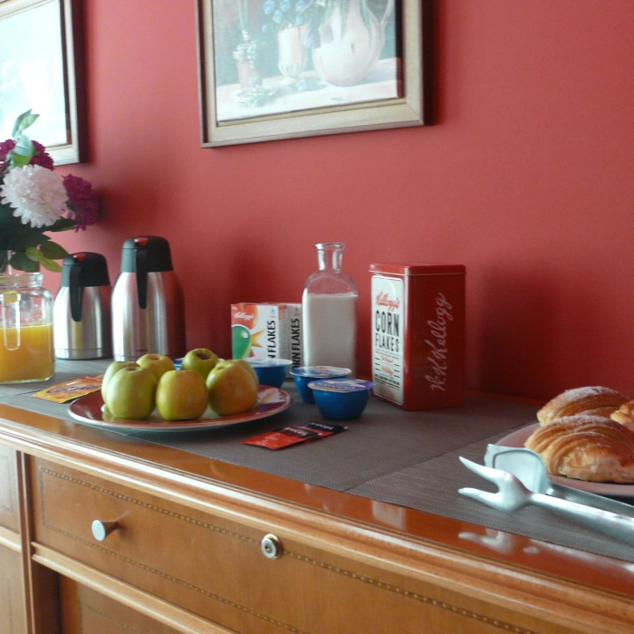 Desayuno en mostrador con frutas, caf&eacute; y pasteles, en habitaci&oacute;n roja
