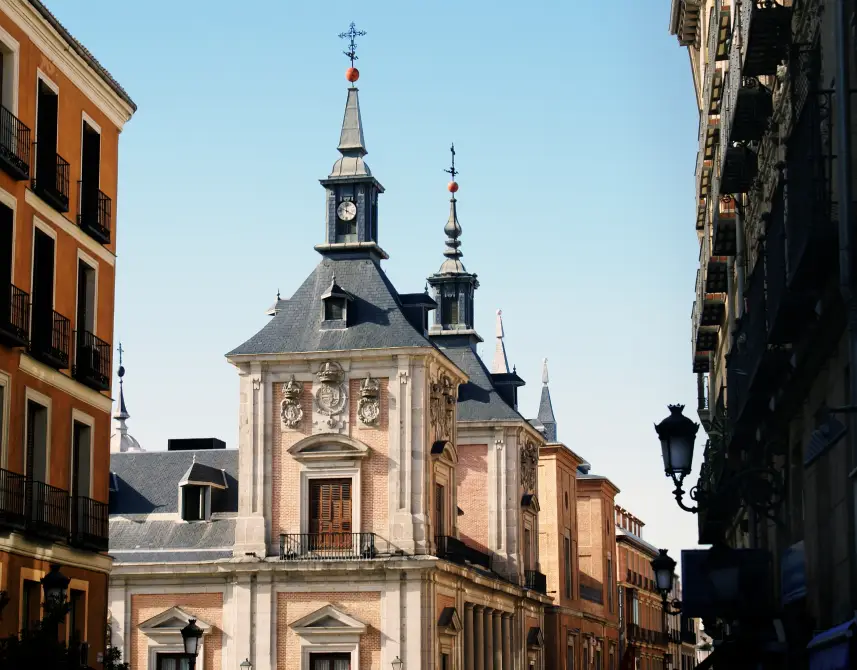 Edificios hist&oacute;ricos con campanarios y reloj bajo cielo azul