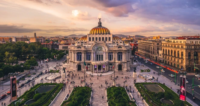Vista a&eacute;rea del Palacio de Bellas Artes con el domo iluminado al atardecer.