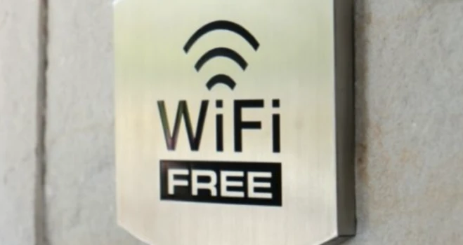 Cartel &ldquo;WiFi FREE&rdquo; con s&iacute;mbolo de se&ntilde;al inal&aacute;mbrica en pared