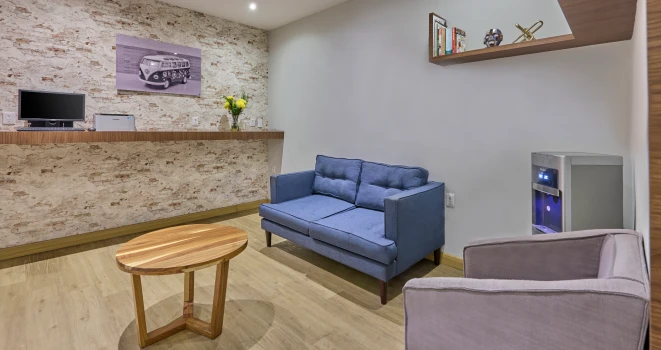 Sala de estar con sof&aacute;s azules y grises, mesa circular y decoraci&oacute;n moderna