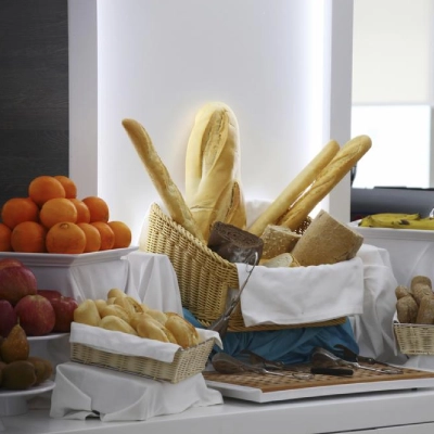 Panader&iacute;a con bollos y panes, junto a naranjas y dulces en vitrina