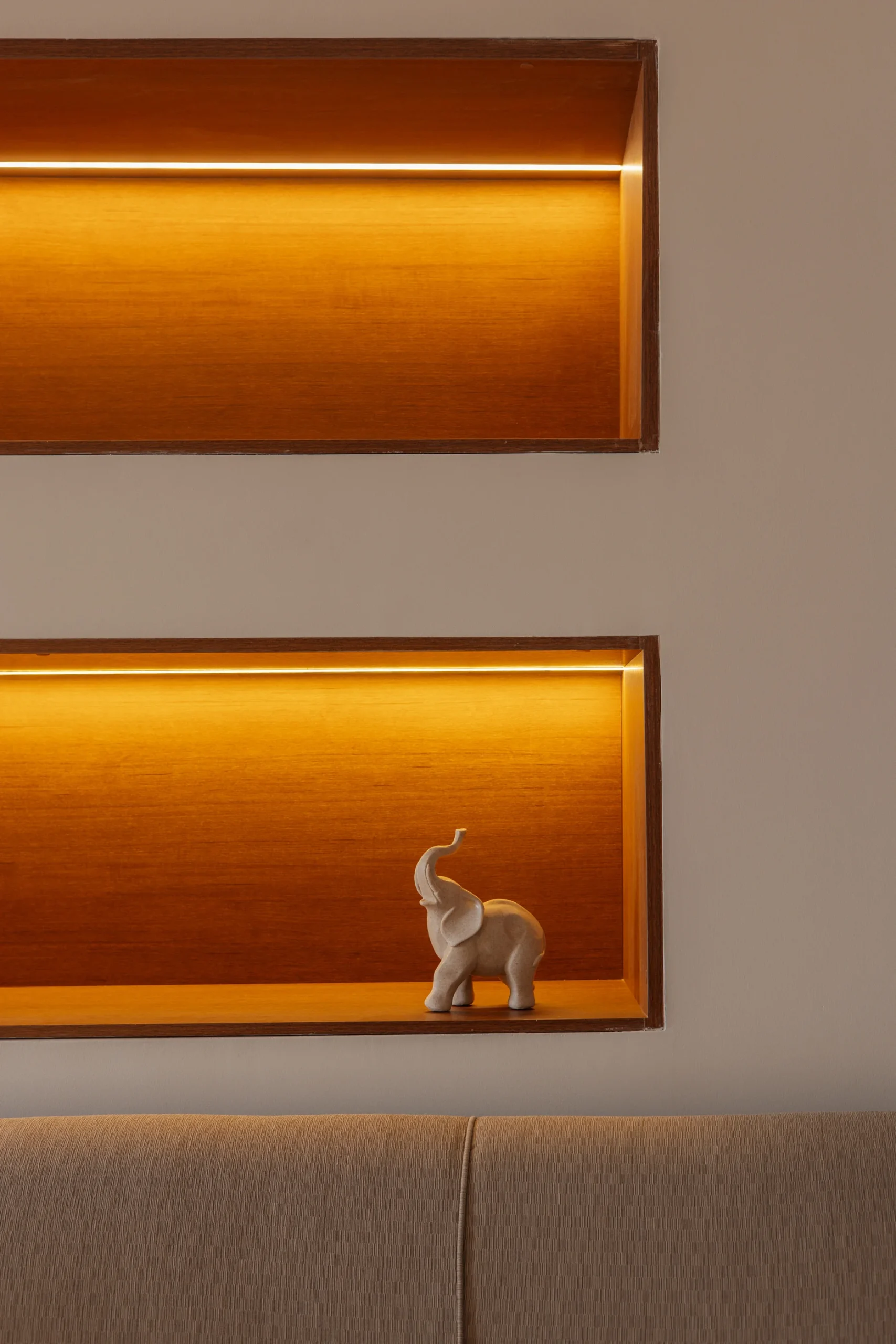 Repisa de madera con luz c&aacute;lida y figura de elefante decorativa.